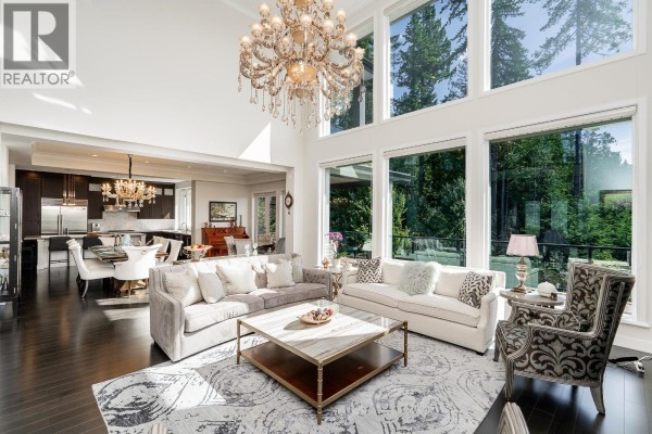 A spacious living room with a high ceiling, large windows, and plush seating. - 22 Heritage Peak Road, Port Moody