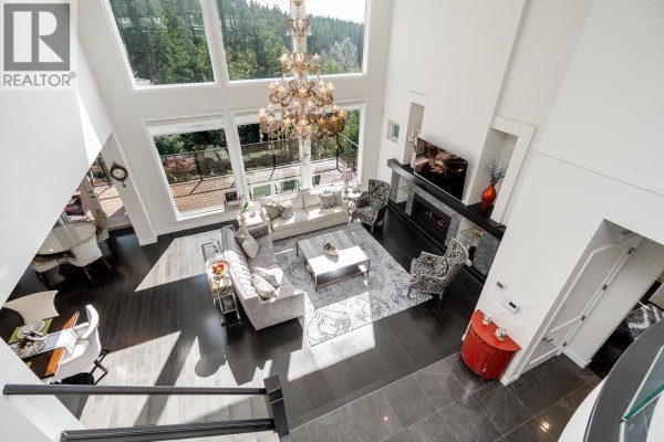 An elevated view of the living room, showcasing the fireplace, windows, and open layout. - 22 Heritage Peak Road, Port Moody