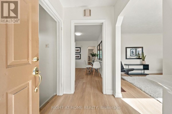 Entryway with light wood floors, leading to a dining area and living room. - 22 Katherine Road, Toronto