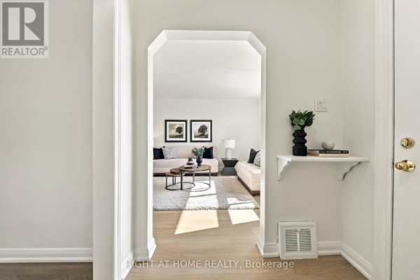 View from entryway arch into a living room with two sofas and coffee table. - 22 Katherine Road, Toronto