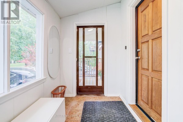 Entranceway of a house with white walls and wooden door. - 22 Long Branch Avenue, Toronto
