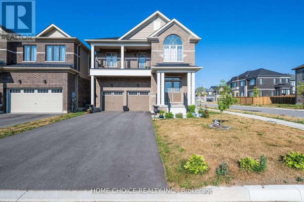 Front view of the detached house with a paved driveway, green lawn, and landscaping. - 22 Ludlow Drive E, Barrie