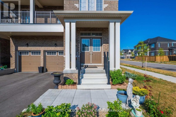 Close-up of the front porch entrance with double doors, steps, railings, and garden statues. - 22 Ludlow Drive E, Barrie