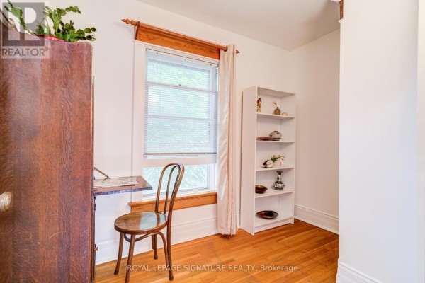 Fold-down desk in a home office with wooden armoire and bookshelf - 22 Peel Avenue Brampton