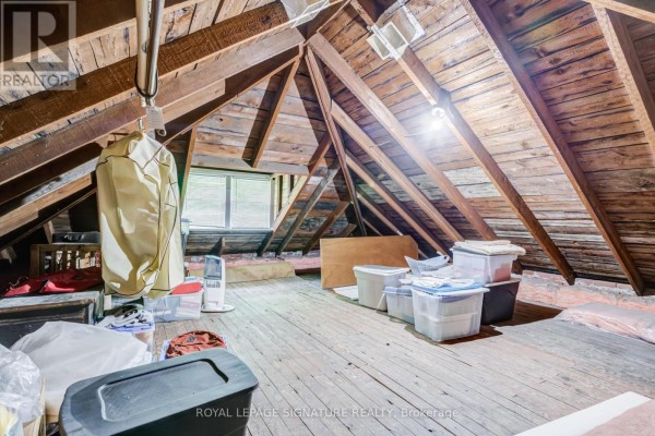 Attic with exposed wooden beams and storage bins - 22 Peel Avenue Brampton