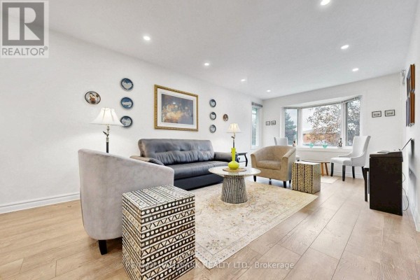 Living room with a bay window, seating area, and a decorative rug on wood floors. - 22 Pining Road, Markham