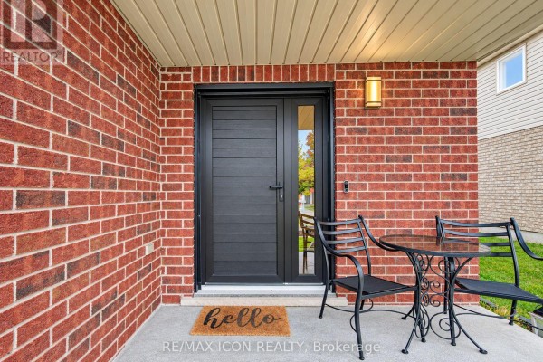 Close-up of the front door entrance with a black door, brick facade, and seating area. - 22 Poffenroth Path, Woolwich