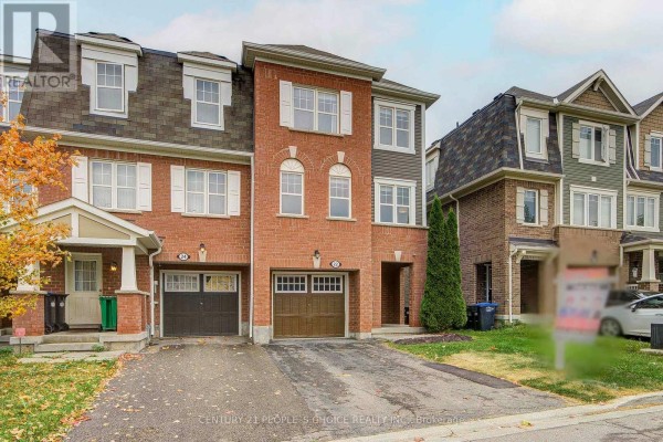 Front view of the townhouse, showcasing its brick facade and arched windows. - 22 Quillberry Close, Brampton