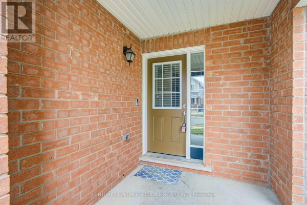 Covered entryway with red brick walls and a beige front door with a glass panel. - 22 Quillberry Close, Brampton
