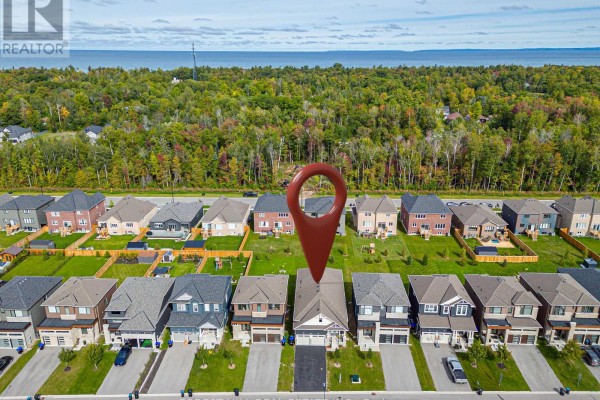 Aerial view of houses with a treeline and body of water in the distance. - 22 Simona Avenue, Wasaga Beach
