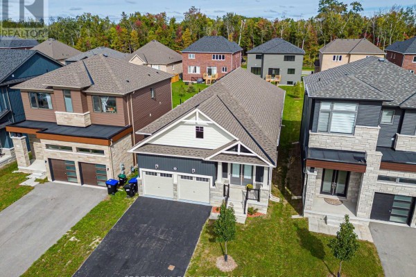 Front view of a modern house with a two-car garage and stone and dark siding. - 22 Simona Avenue, Wasaga Beach