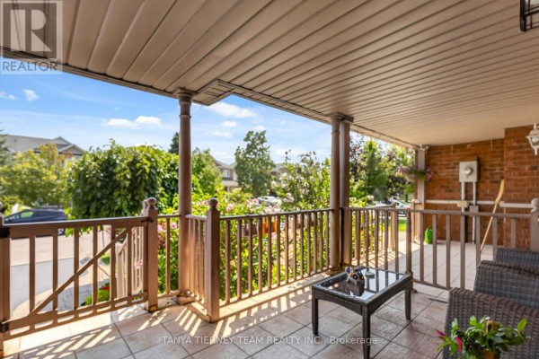 View from the covered front porch looking out over a street with trees. - 22 Sinden Drive, Whitby