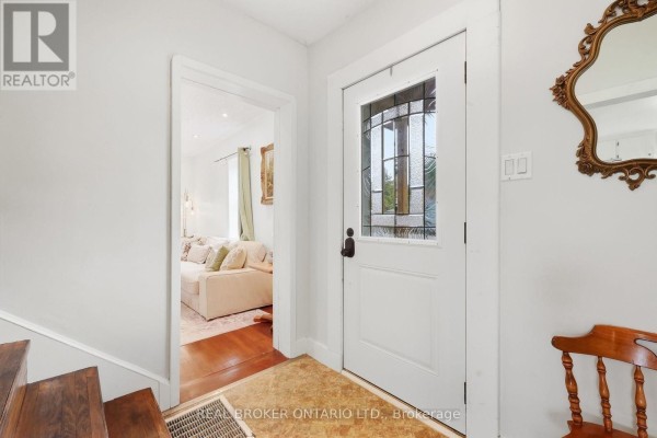 Interior view of the front door with a stained-glass pane, leading into a bright hallway. - 22 Temperance Street, Perth East