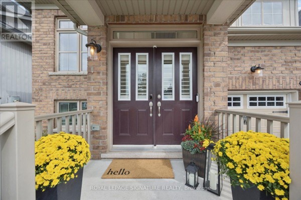 Close-up of the front door with glass panels and flanking decorative planters. - 22 Wycombe Street, Whitby
