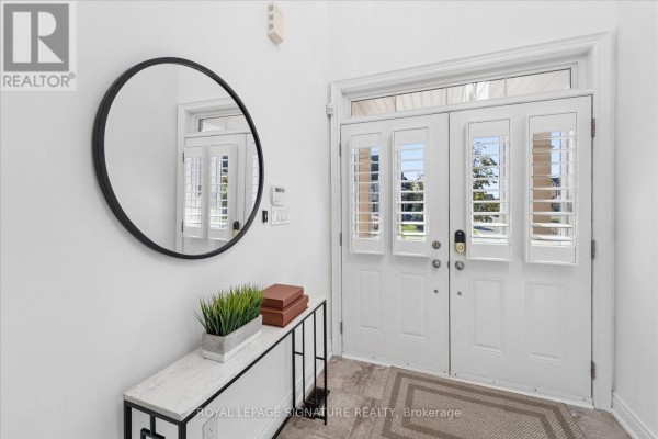 Foyer with white double doors, a round mirror, and a console table. - 22 Wycombe Street, Whitby
