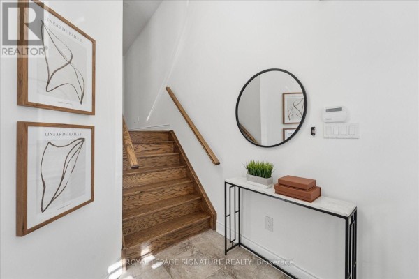 Foyer with stairs, a round mirror, a console table, and framed wall art. - 22 Wycombe Street, Whitby