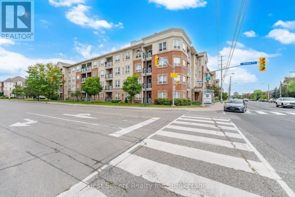 Corner view of the apartment building from street level with a crosswalk and traffic. - 220 - 60 Mendelssohn Street, Toronto