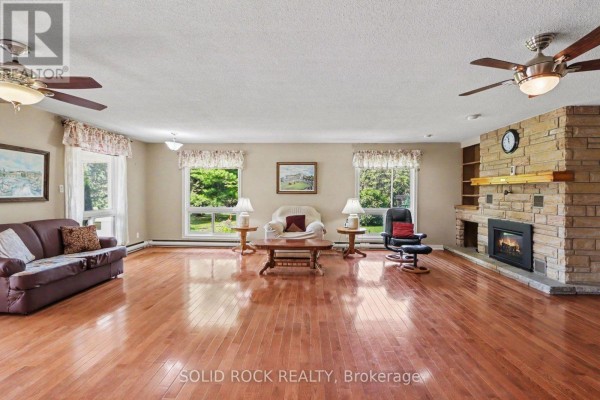 Kitchen with wood cabinets, white subway tile backsplash, and a dining table. - 220 Highfield Crescent, Beckwith