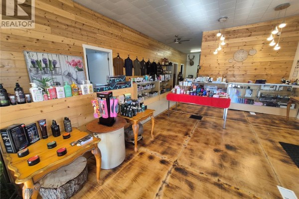 Retail space interior with wood walls, display shelves stocking hair products, and polished wood floors. - 220 Main Street, Bengough