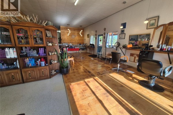 Hair salon interior featuring styling chairs, wood cabinets with hair products, and wooden floors. - 220 Main Street, Bengough