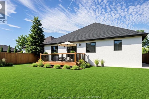 Rear view of the house showcasing a wooden deck with outdoor seating and a green lawn. - 220 Ross Crescent, Essex