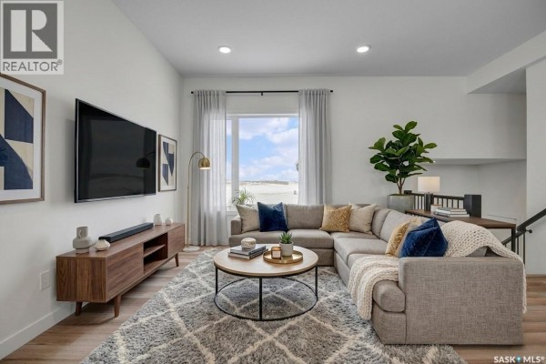 Open-concept kitchen featuring stainless steel appliances, white cabinetry, and a dining area - 220 Veterans Drive, Warman