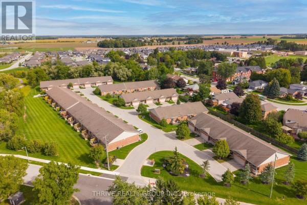 Aerial view of a suburban neighborhood with rows of townhouses and surrounding green spaces. - 220 Walnut Street, Lucan Biddulph
