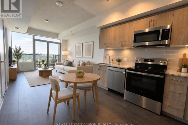 Open-concept living and kitchen area with dining table, sofa, and stainless steel appliances. - 2201 - 4010 Eglinton Avenue W, Toronto