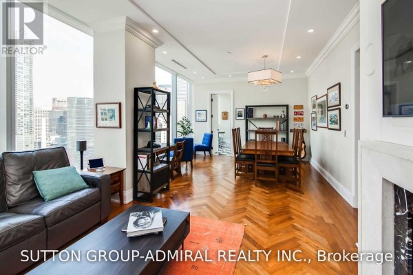 Open concept living and dining area with wood floors, fireplace, and city views. - 2202 - 183 Wellington Street W, Toronto