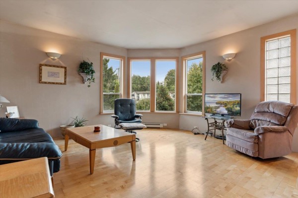 Interior entryway with tiled floors, a wooden staircase, double front doors, and large potted plant. - 2203 Windsor Street, Abbotsford