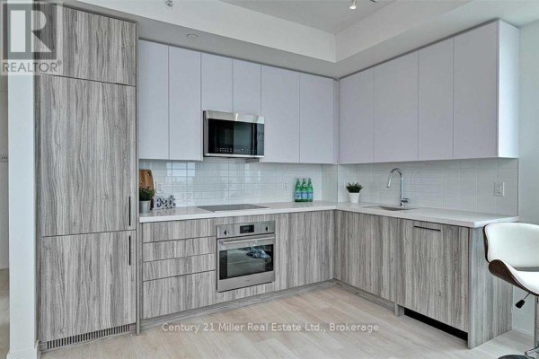Modern kitchen with grey wood grain cabinets, white counters, and stainless steel appliances. - 2204 - 297 Oak Walk Drive, Oakville