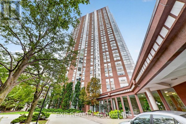 Exterior view of a brick apartment building with a covered entrance and glass windows on the ground floor. - 2204 - 7 Concorde Place, Toronto