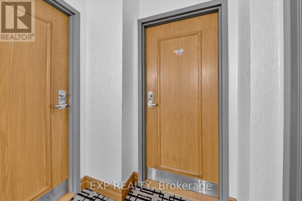 Close-up of two closed wooden apartment doors with silver hardware and grey frames on a carpeted hallway. - 2204 - 7 Concorde Place, Toronto