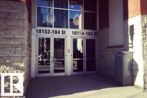 An open-concept kitchen and living area with large windows and city views. - #2204 10152 104 St Nw, Edmonton