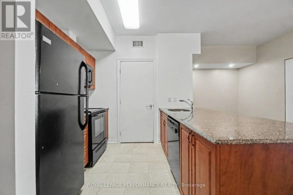 View of the kitchen area featuring a refrigerator, stove, dishwasher, and island with sink. - 2205 - 234 Rideau Street, Ottawa