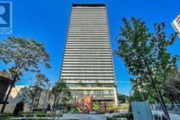 View of the building from the park area with greenery and sculptures - 2205 - 575 Bloor Street E, Toronto