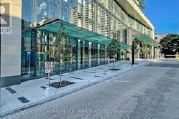 Ground-level view of the entrance with glass canopy and landscaping - 2205 - 575 Bloor Street E, Toronto