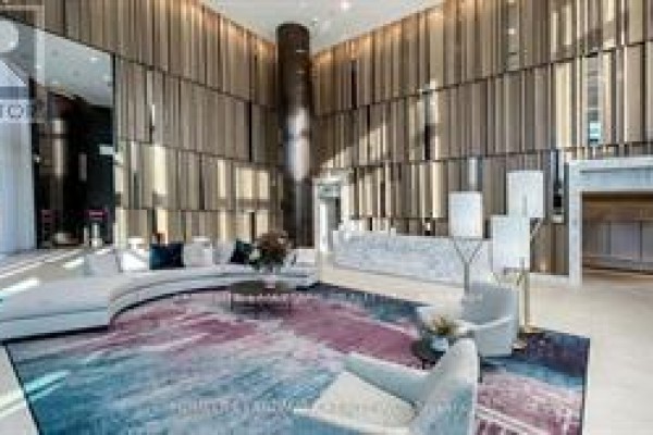 Lobby interior featuring modern seating, wood paneling, and a reception desk - 2205 - 575 Bloor Street E, Toronto