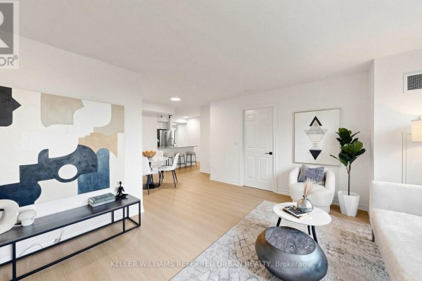 Hallway with light wood flooring, white walls, and a large framed abstract artwork. - 2205 - 761 Bay Street, Toronto
