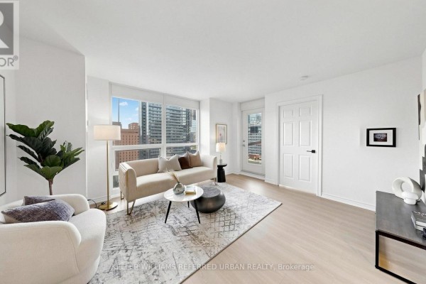 Open concept living and dining area with light wood floors and modern furniture. - 2205 - 761 Bay Street, Toronto