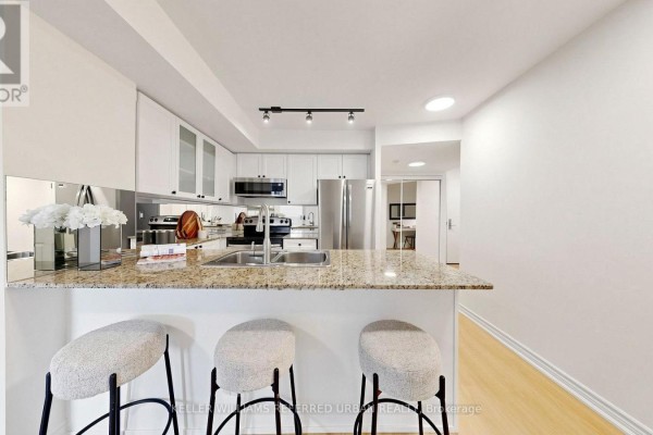 Kitchen with white cabinetry, granite countertops, stainless steel appliances, and a dining area. - 2205 - 761 Bay Street, Toronto