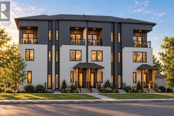 Front exterior of modern townhouses with white and dark grey paneling and covered entryways. - 2205 1 Street Ne, Calgary