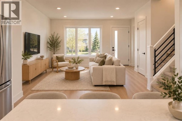 Living room with large window, beige sofa, wooden media console, and light wood floors. - 2205 1 Street Ne, Calgary