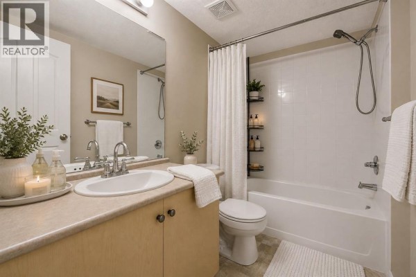 Bathroom with vanity, toilet, and bathtub with shower. - 2206, 16969 24 Street Sw, Calgary