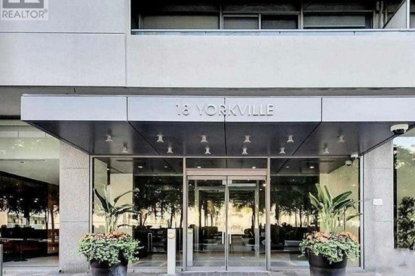 Entrance to 18 Yorkville Avenue condo building with glass doors and planters. - 2206 - 18 Yorkville Avenue, Toronto