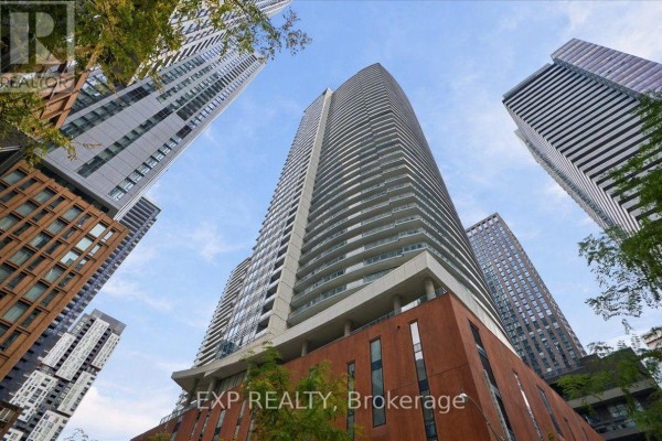 Tall apartment building exterior viewed from below with a blue sky. - 2206 - 21 Widmer Street, Toronto