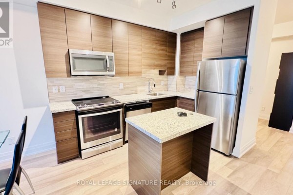 Modern kitchen with dark wood cabinets, granite countertops, stainless steel appliances, and an island. - 2206 - 3600 Hwy 7, Vaughan