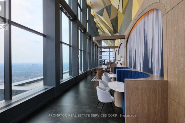 Modern lounge area with curved booths, marble tables, and panoramic city views. - 2207 - 1 Concord Cityplace Way, Toronto