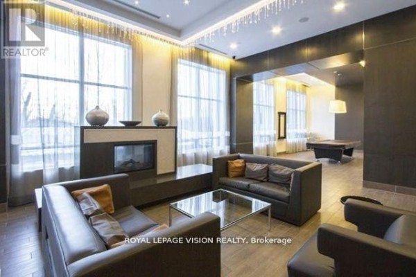 Apartment building lounge area with fireplace, seating, and pool table. - 2207 - 181 Wynford Drive, Toronto