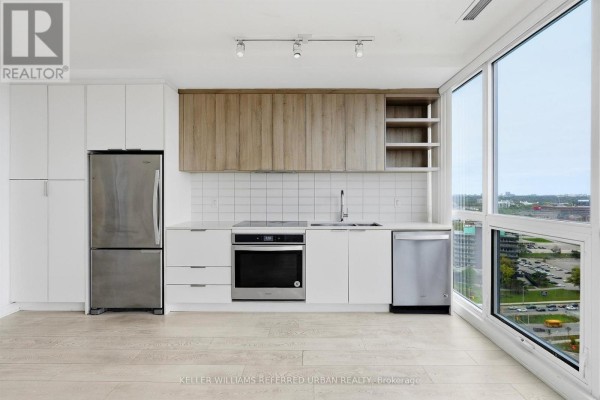 Modern kitchen with stainless steel appliances, white cabinetry, and wood accents. - 2207 - 6 Sonic Way, Toronto